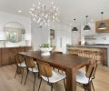 In the dining room, Visual Comfort Pastiche Large Table Lamps from Harper House Design sit atop a buffet. Four Hands Jared Dining chairs from Harper House Design surround the dining table, lit by the Bertjan Pot for Moooi, Heracleum II chandelier from DWR.