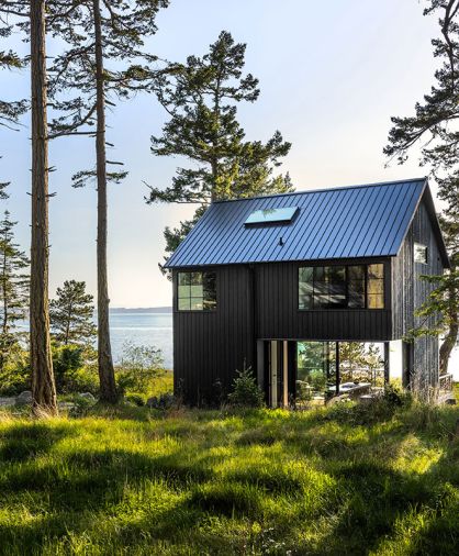 Views from the home include the Sound, a protected wetland, and a bald eagle nest. The home’s exterior utilizes common materials installed unusually. The board and batten siding has been installed in reverse. The dark stain minimizes visual noise from the wood’s knotty appearance.