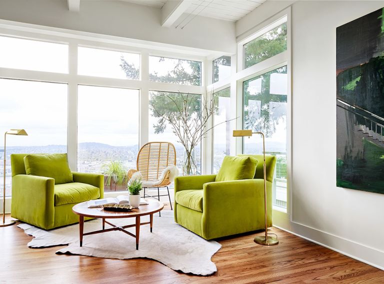 Falvey favors green, including these Lee Industry chairs and Bay Area artist Chris Brown’s artwork. Benjamin Moore Simply White adds pop to the furnishings juxtaposed against Lord’s wicker chair. The circular West Elm coffee table atop a hide rug adds contrast to refinished red oak floors.