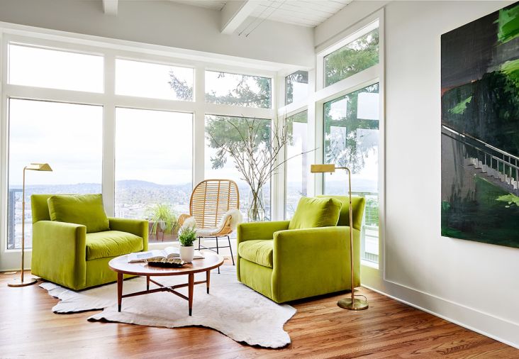 Falvey favors green, including these Lee Industry chairs and Bay Area artist Chris Brown’s artwork. Benjamin Moore Simply White adds pop to the furnishings juxtaposed against Lord’s wicker chair. The circular West Elm coffee table atop a hide rug adds contrast to refinished red oak floors.