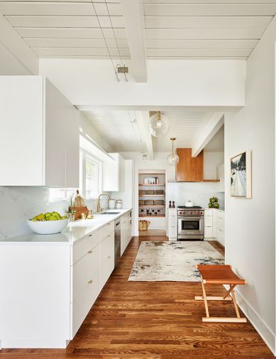 An ever-ready Wolf range from Basco Appliances is flanked by handy Rockwood Cabinetry and quartz backsplash and countertops from Architectural Surfaces. Kable System lighting team with Visual Comfort pendants from Accent Lighting. Colonial Hardware from Hardware Hut.