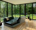 In the top floor observatory, the custom lounger is designed by William / Kaven Architecture and manufactured by Arrow Furniture Works. The flooring is white oak with a black walnut inlay, installed by Custom Wood Flooring LLC, while the windows and doors throughout are Sierra Pacific.