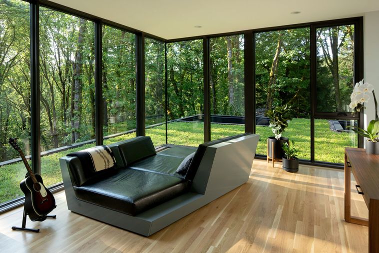 In the top floor observatory, the custom lounger is designed by William / Kaven Architecture and manufactured by Arrow Furniture Works. The flooring is white oak with a black walnut inlay, installed by Custom Wood Flooring LLC, while the windows and doors throughout are Sierra Pacific.