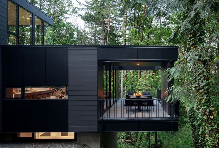 On the second-floor terrace, Navene Outdoor Dining Chairs from CB2 surround a Four Hands, Simone Bistro Table from Burke Decor. The smooth siding is a James Hardie Reveal Panel in black, from Pacific Architectural Products, while the lap siding is painted William / Kaven Bronze.