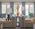 The orientation of the furniture allows for ample seating with ocean views. Elegant Massucco Warner custom sofas, chair and ottoman, draperies, and chair upholstered in Romo Fabrics from Trammell-Gagné warm the room. A Hwang Bishop Incense lamp sits atop a White Oak tray table from Kelly Forslund.