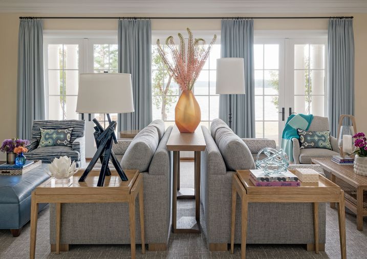 The orientation of the furniture allows for ample seating with ocean views. Elegant Massucco Warner custom sofas, chair and ottoman, draperies, and chair upholstered in Romo Fabrics from Trammell-Gagné warm the room. A Hwang Bishop Incense lamp sits atop a White Oak tray table from Kelly Forslund.