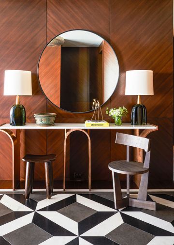 Chevron patterned walnut wood paneling by Stusser Woodworks. Porta Romana green glass blown lamps from Jennifer West Showroom atop vintage metal console with stone slab top.
