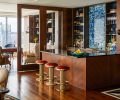 Art Deco stools from J Garner Home by J. Alexander face The Stone Collection’s backlit Blue Agate Slab. Harriet Industries antiqued brass countertops and shelves. Custom door and Fumed Oak casework with Brass Metal Screed details and leather panels by Stusser Woodworks.