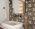 The showstopper of the renovation, the powder room, became the basis of the Santa Barbara theme. The tile included elements to please both homeowners – his darker, warmer aesthetic with her flair for the decorative.