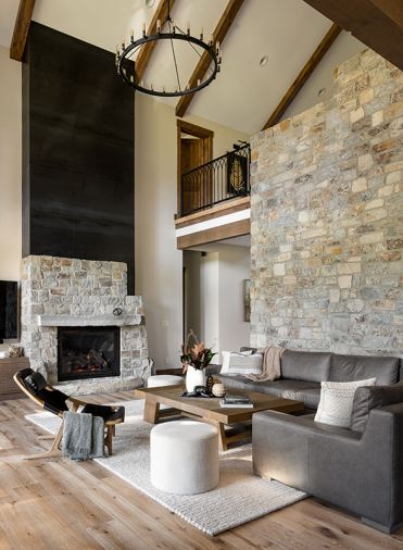 The living room is anchored by the stone wall, and a stone and black steel fireplace, the latter with a Kozy Heat, Carlton 46 gas fireplace from Thomson Heat.