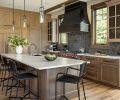 In the kitchen, RH Machinist Cylinder Glass Pendants hang above the substantial island, topped with an Adacia Quartzite Honed countertop from Stonewood Design. The clear and knotty Alder cabinetry throughout is from Sky River Industries.