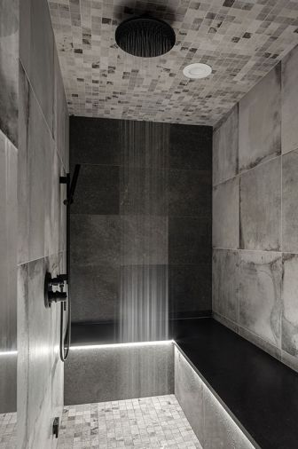 The steam shower is wrapped in tile from Stonewood Design, with a Delta plus Mr. Steam, steam system rain shower from Ferguson.
