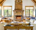 In the great room, a soaring fireplace composed of Montana Moss Rock from Select Stone is a focal point. The Hunter Douglas window coverings are from Cindy’s Window Fashions, the white oak flooring from Pioneer Millworks.