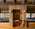 “The bunk room was all basically custom hand built with our finish carpenter,” says Redding. Rustic red cedar casework is by Beamworks, in Oyster Bay color. The sconces flanking the desk are from Pottery Barn, and the bunk lighting from Schoolhouse.