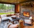 The protected back patio has a fireplace with a stone surround and hearth from Select Stone, and custom ironwork. The chairs and sofa from RH are paired with a custom antler light from Crooked Creek, and a handmade, hand-dyed wool rug from the Tallerocho8 workshop in Teotitlán del Valle, Mexico.
