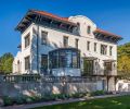 The south elevation of the 1910 Mediterranean Revival home with updated Orangerie. New custom wood Quantum Windows throughout. Former pink-painted stucco now Sherwin Williams Luxon custom matched to Farrow & Ball Pointing No. 2003 masonry paint. Original clay tiles.