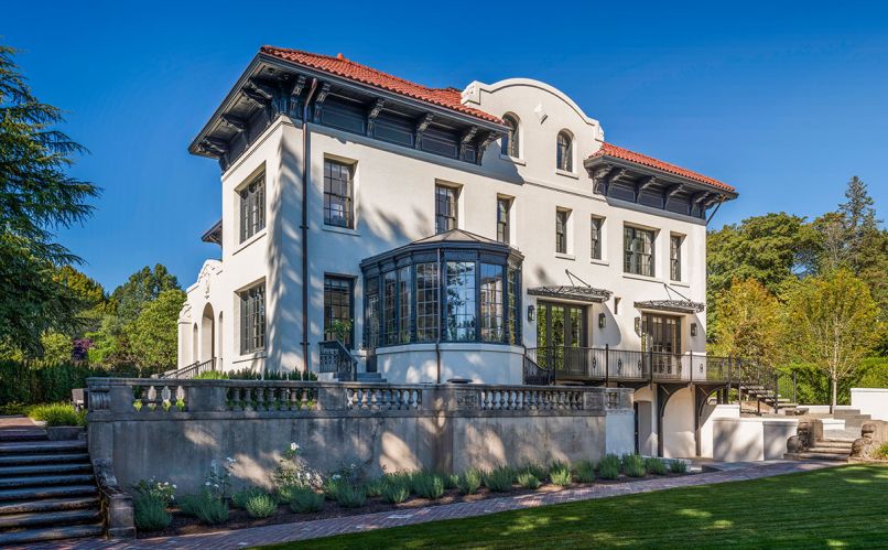 The south elevation of the 1910 Mediterranean Revival home with updated Orangerie. New custom wood Quantum Windows throughout. Former pink-painted stucco now Sherwin Williams Luxon custom matched to Farrow & Ball Pointing No. 2003 masonry paint. Original clay tiles.