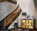 Missing c. 1922 bronze “S” railing was recast for Potoro marble staircase. Dingy walls refreshed with limewash plaster by Studio C. Stunning brass Necchi sideboard from Natasha Baradaran. Uteki painted lamp from Anthropologie and bronze Amsterdam Chair from Magni Home Collection.