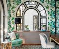Cheerful Thibault Open Spaces wallpaper highlights a Bakalowits & Sohne Miracle Chandelier. An Anthropologie Bixby chair and RH Holden Side Table sit atop Hedgehog in Sea from The Rug Company.