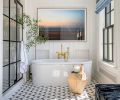 The bathroom features a Luxurious Kaldewei Centro Duo tub, framed photography by Aaron Leitz, Waterworks Henry tub filler, Ann Sacks Benton Clara mosaic tile flooring and Pepperbox Solarium Skylight custom shower door. Wood paneling by Northwest Custom Interiors.