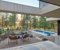In lounge located in the back of the house, a cut-out in the roof allows stargazing from the custom hot tub. The in-ground pool is custom built with a retracting safety cover and black brick coping, by SPS Specialized Pool Services.