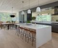 In the kitchen, quartz counters top Mirlux cabinetry with a striking antique glass backsplash. Pella Windows & Doors of Portland provided windows and doors throughout.