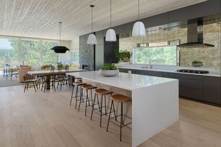 In the kitchen, quartz counters top Mirlux cabinetry with a striking antique glass backsplash. Pella Windows & Doors of Portland provided windows and doors throughout.