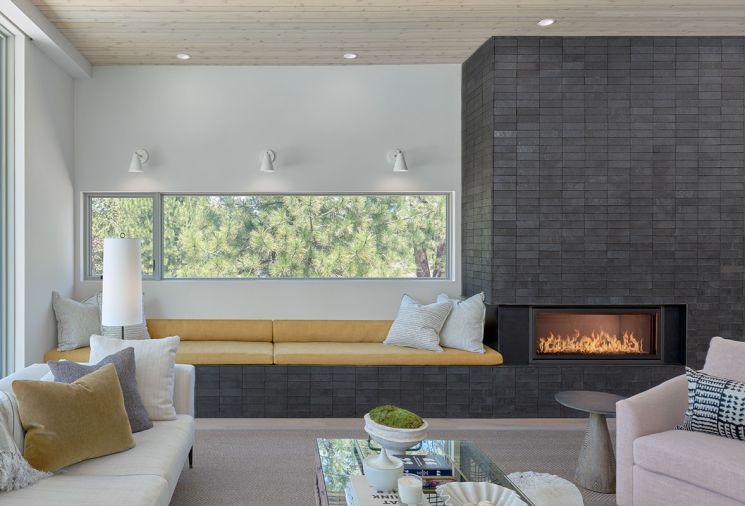 At the fireplace, the glazed brick veneer is from Fireclay in the Absaroka color. The window seat cushion is covered in Mustard Linen by Holland and Sherry.