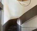 The stunning staircase handcrafted onsite by Beautiful Custom Stairs, features Arabescato Black stone treads from Architectural Stone Werkes and a Twisted Metalworks steel bar rail.