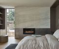 A Calacatta Caldia marble crowns the Montigo fireplace from Thompson Home and Hearth and teams with a custom ottoman from Village Interiors. The Arris Tub Bed is from Kelly Forslund with an Altura Wood Bed Frame.