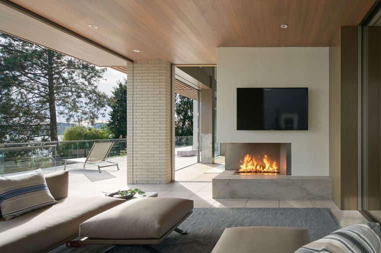 Outdoor space features Mason-Lite fireplace and Indiana Limestone pavers set level to allow water to drain between cracks. Columns trimmed in Ivory Brick from Mutual Materials play off indoor outdoor cedar soffits.