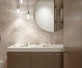 The powder bath features cabinetry from Northwest Custom Interiors, a Silver Sands stone wall, and Tech Lighting from Alva Pendants.