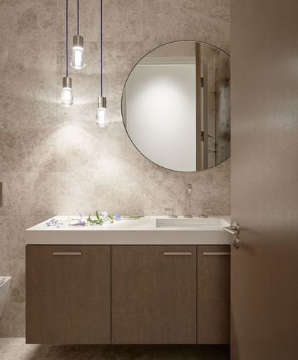The powder bath features cabinetry from Northwest Custom Interiors, a Silver Sands stone wall, and Tech Lighting from Alva Pendants.