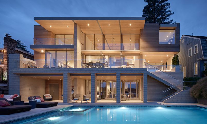 The cedar lap siding is from Ramquist Construction. Sky-Frame glass wall in Great Room features two electric doors, with the other windows from Glasbox™ Windows and Doors. Surrounding the pool, Fujiwa Tile, and elegant furnishings from Terris Draheim Outdoor.