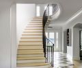 In the entry, the existing floor and staircase were maintained, and an Arctic Halo from Fine Art Handcrafted Lighting added. The Sprunks “wanted to ‘Sprunkify’ the home and make it their own,” says contractor Pete Lacic. Benjamin Moore “White Dove” paint was applied throughout.