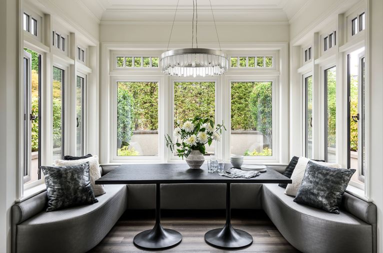 The “game nook” off the living room has custom window seats covered in Lexington vinyl, designed by Ronda Divers Interiors, and created by Classic Interior Concepts. The benches surround a custom Abaco Dining Table by Robert James, with a Lior Round Pendant overhead, from Fine Art Handcrafted Lighting.
