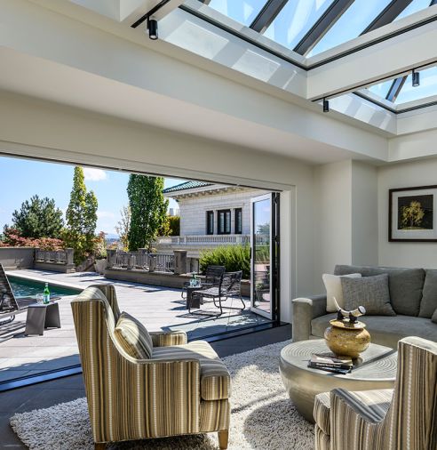 The pool house was reconfigured into a guest suite, and now opens to the pool with new NanaWall folding glass doors. It has a kitchenette, bathroom, and Murphy bed, as well as a Cornerstone Sofa from Century Furniture and Collin Chairs by Jessica Charles.