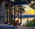 Siena, the dog, takes a moment to enjoy the spectacular sunset view from this tree-filled lot. Locally sourced timber, pivoting doors, and an open framework between the interior and exterior provide an unfettered connection between the kitchen, deck, and the photogenic surroundings.