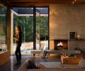 Tucked under the view windows, a salvaged pier beam has been cleverly reimagined as a discrete media station. A television can rise from the hollowed timber where it lives, tucked into the flooring and out of site.