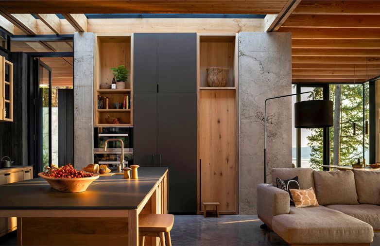 Approaching the cabinetry with a furniture mindset, custom rustic white oak cabinets from Sparrow Woodworks cultivate a less uniform, more lived-in atmosphere. The kitchen is rounded out with Miele appliances, Crossville porcelain countertops in Film Noir and custom dark gray paint.