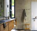 Keeping with the ethos of cabinetry-as-furniture, Sparrow Woodworks’ custom oak cabinets also grace the bathroom. Crossville porcelain countertops from Creative Countertops. The poured concrete floors give way to a shower floor of Ann Sacks Salluto Mosaics tile in Nero.