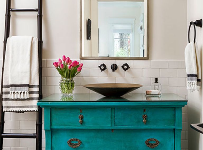 Karen found the antique teal dresser and Brian converted it to a sink console, the jumping-off point for the guest bathroom. The Robert Abbey Mini Chandelier from Chown Hardware and Los Jardine tile from Ann Sacks complete the bohemian vibe.