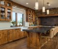 In the kitchen, the Superior Alder cabinetry is by Norman Wood Products, a division of Norman Building & Design, and topped with two different colors of polished Caesarstone.