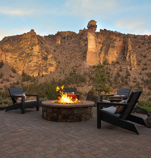 Cabinet Ridge Ledgestone in dry stack formation by Fristrom Masonry composes the custom firepit. Around it sits several Larnaca Outdoor Metal Deck Chairs from Williams Sonoma Home.