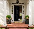 Maison, Inc.’s classic Colonial style new door with sidelights along with the family’s French Bulldog pup welcome visitors.