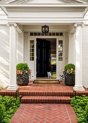 Maison, Inc.’s classic Colonial style new door with sidelights along with the family’s French Bulldog pup welcome visitors.