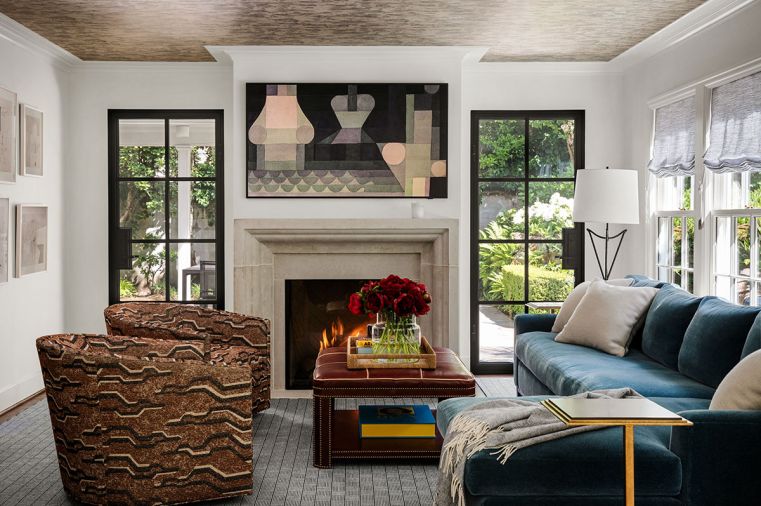 Maison, Inc. transformed a tiny smoking room into a family room warmed by a Francois and Co. fireplace with a shimmering Prato wallcovering ceiling by Nobilis from Kelly Forslund.