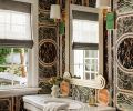 An existing vintage powder room sink gets star treatment set against a Gucci marble print wallcovering. The Art Deco style Tennyson Mirror is flanked by a pair of Hockney Sconces from Urban Electric Co. that echo the wallcovering’s array of color.