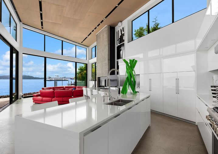 In the kitchen, the white lacquer cabinetry, Thermador appliances and hood insert, and Caesarstone Super White Quartz is all from Pedini NW. The ceiling has a custom recessed slot that allows flexibility in fixture aiming and location, designed by Dark Light Design.