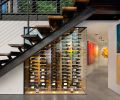 The glass wine display turns vino into art, while the corridor has more wall space to hang art. The artwork in the foreground is from Peri G Fine Art in Palm Springs.